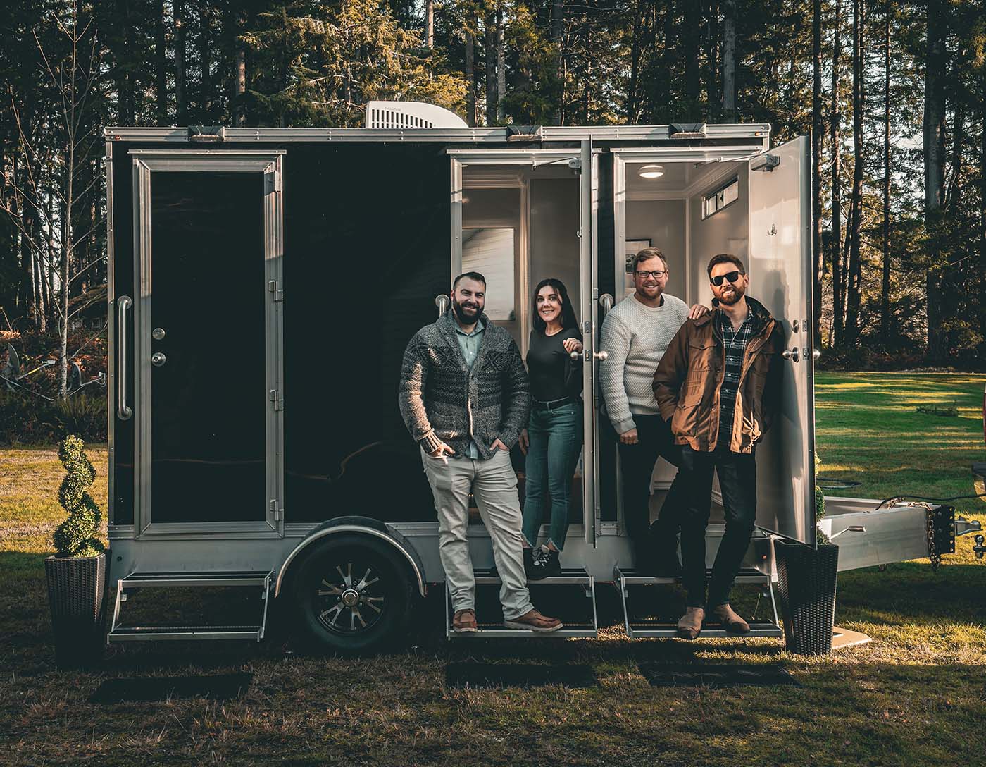 First Class Facility Team standing in front of Portable Bathroom Rental & Septic Services on Vancouver Island