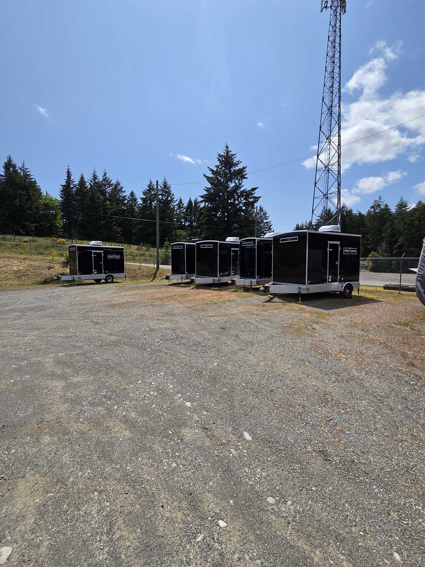 Row of black portable restrooms outdoors