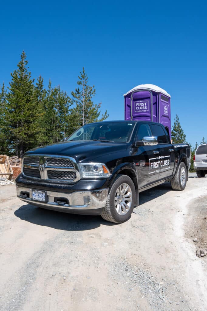 Truck with portable toilet in background