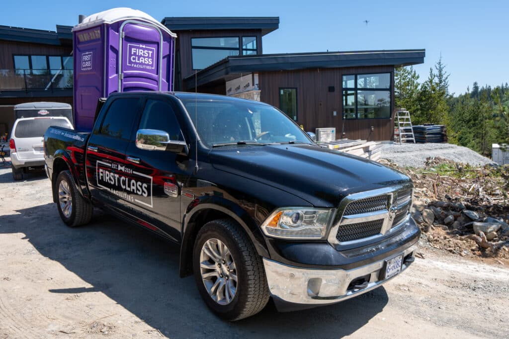 Black truck with portable toilet nearby