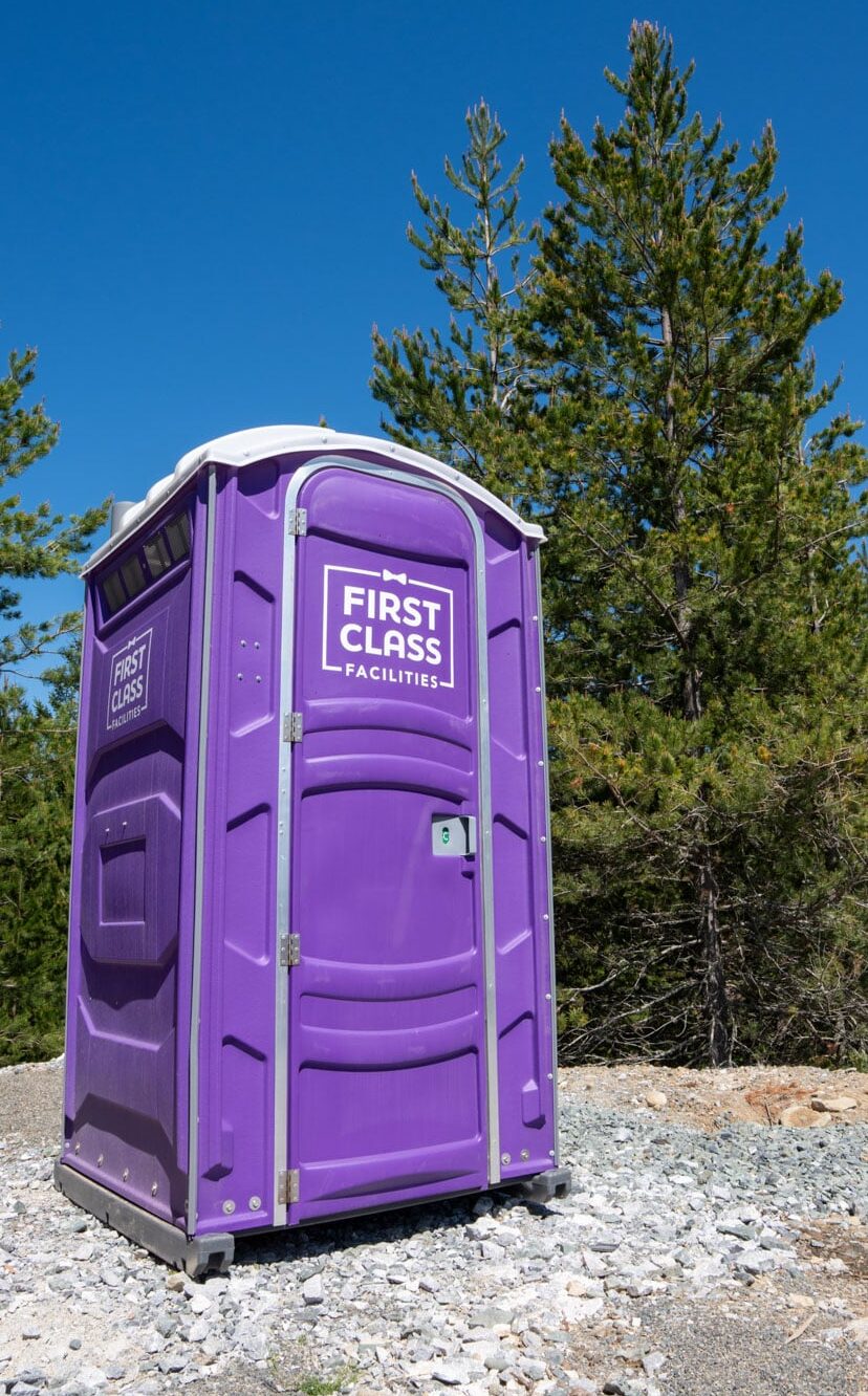Purple portable toilet rentals in nature